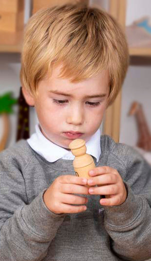 Boy playing with a wooden alphabet character