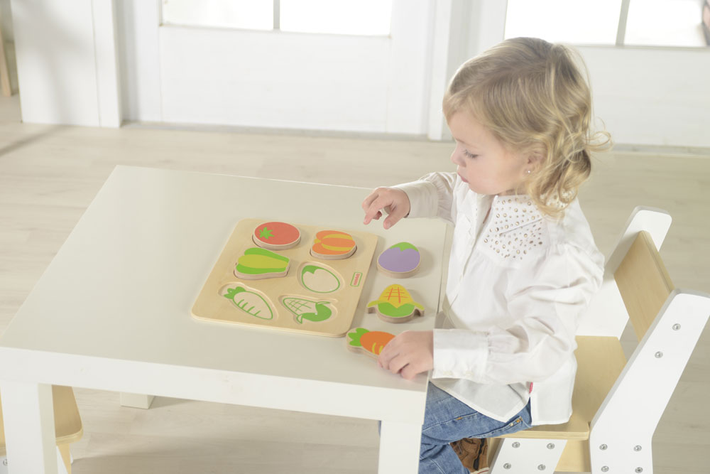 Child playing with a Chunky wooden vegetable wooden puzzle