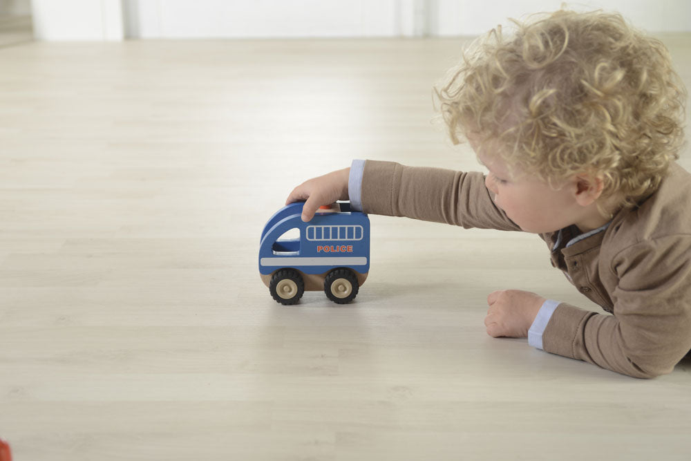 Boy playing with a Wooden police car